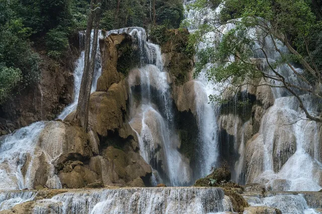 Water flowing over the limestone tiers of Kuang Si Falls in Laos.